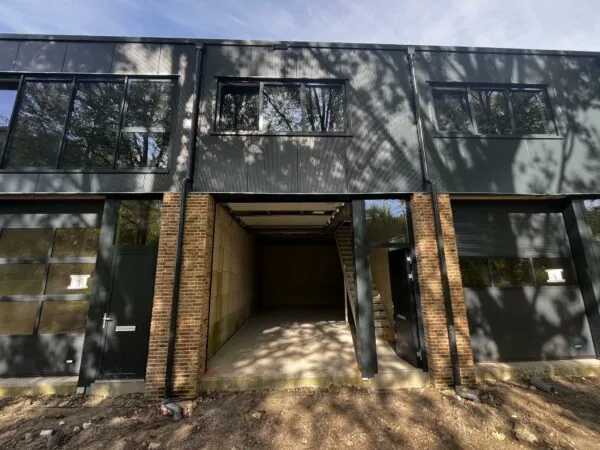 Voorgevel van een modern bedrijfsgebouw aan de Broekdijk-West met deunits 3, 4 en 5 en een openstaande garagedeur.